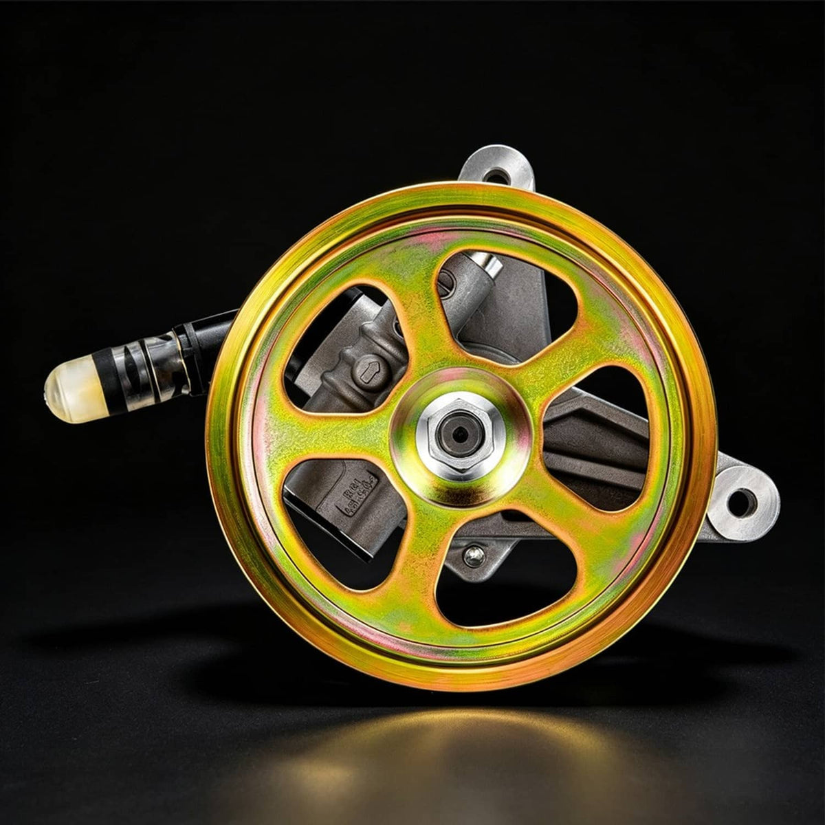 Power steering pump rear pulley view with rainbow wheel and hose connection fitting.