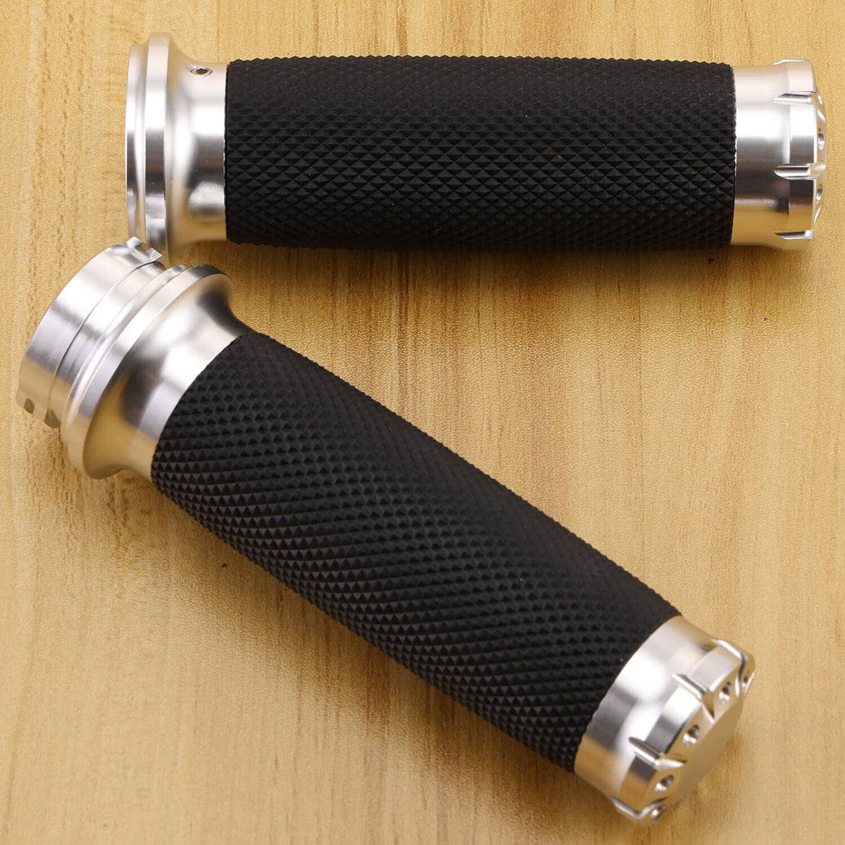 Black textured motorcycle handlebar grips with chrome end caps on silver mounts