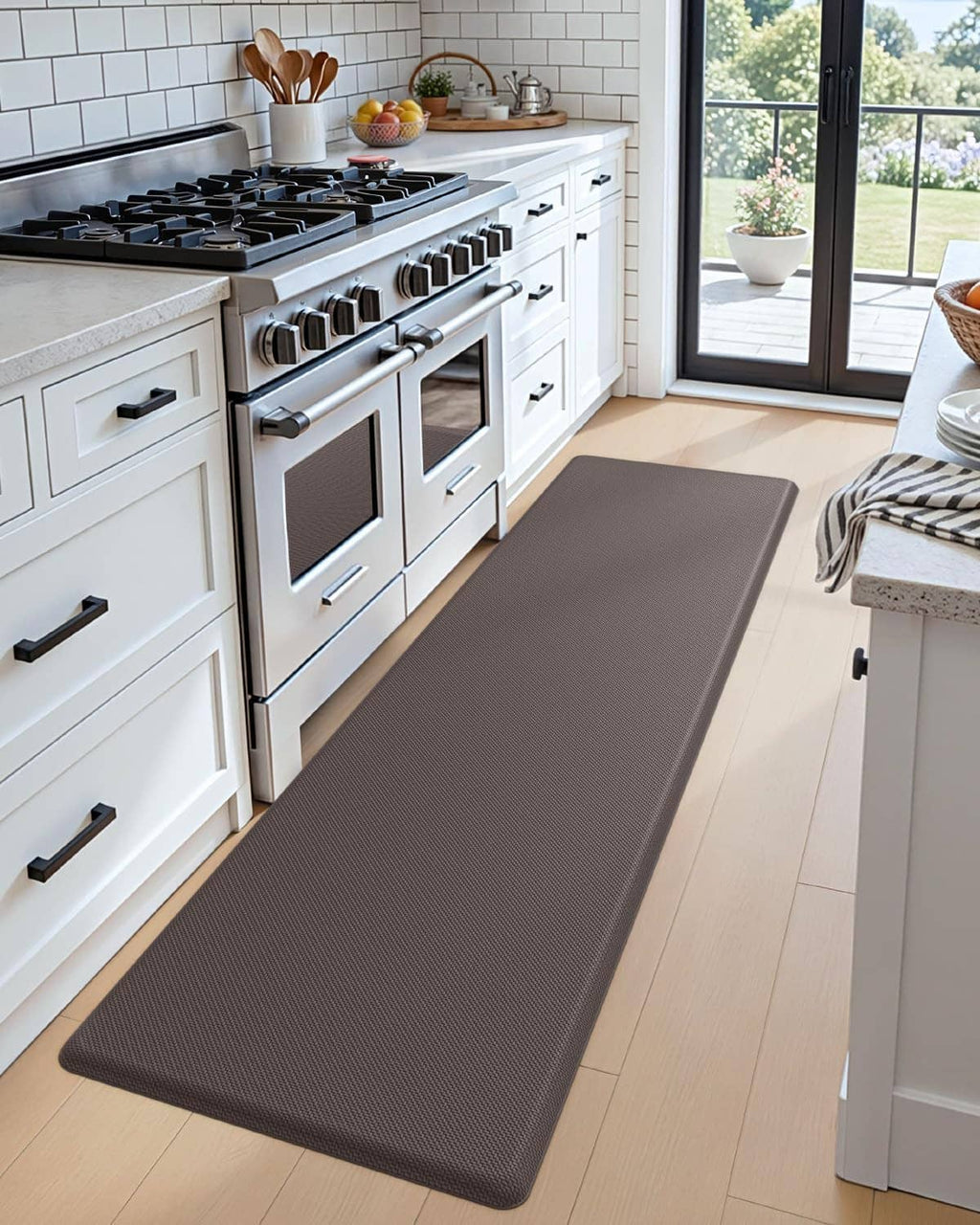 Large anti-fatigue kitchen mat on hardwood floor, dark gray textured surface