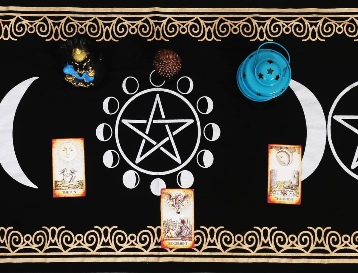 Black altar cloth close-up with white pentagrams, moon phases, and central sigil