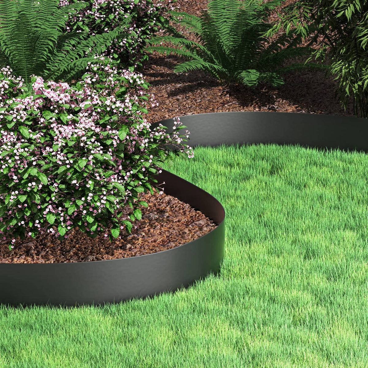 Black curved garden edging around mulch and low shrubs, separating green lawn