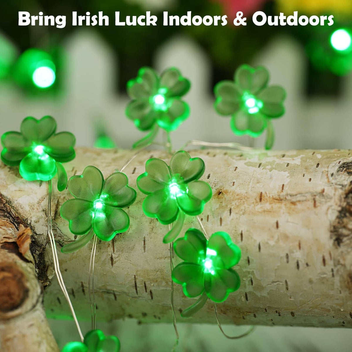 Green shamrock string lights glowing across a cut birch log surface