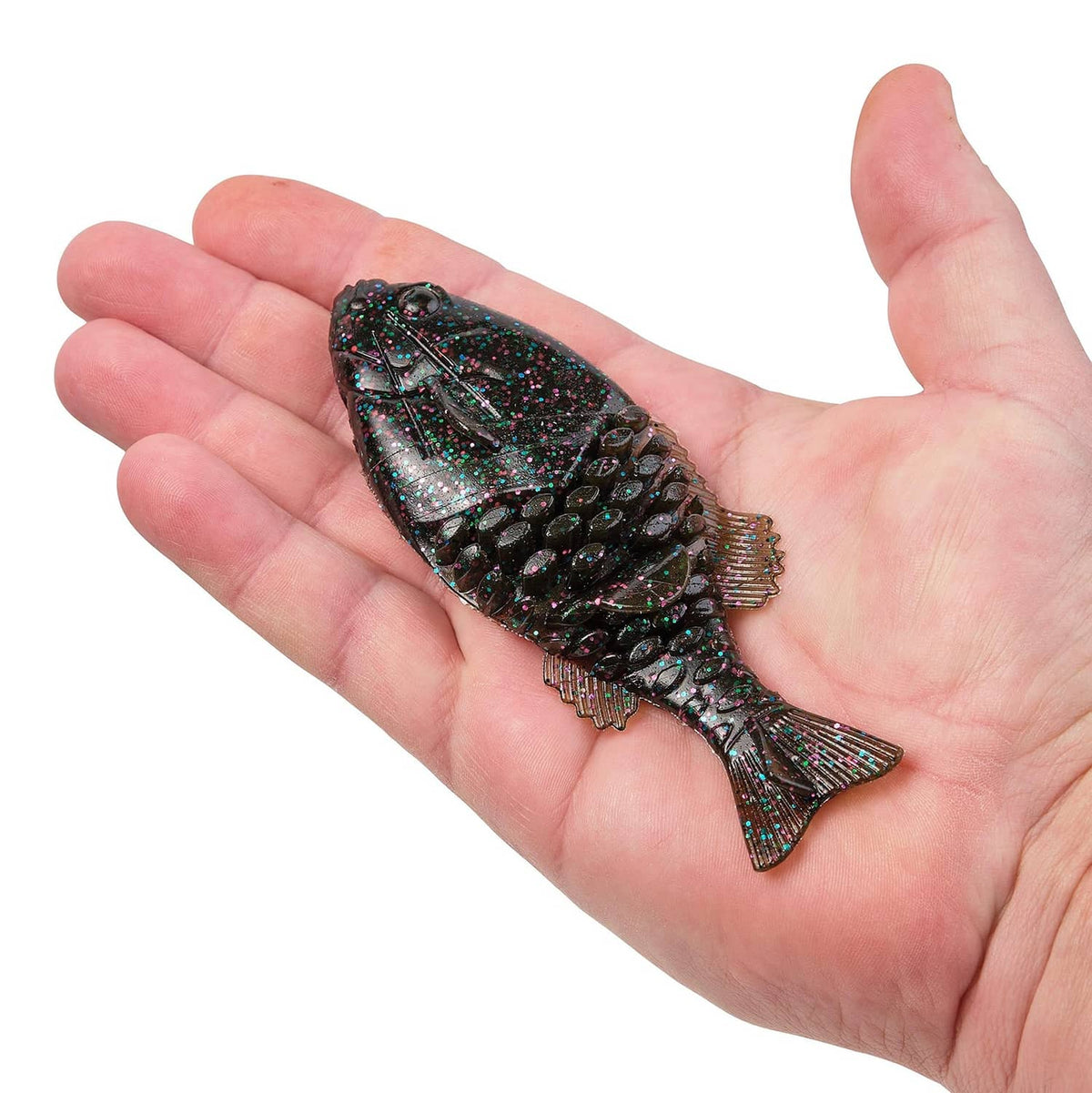 Soft plastic fishing bait in hand, dark glitter body with gill texture and tail