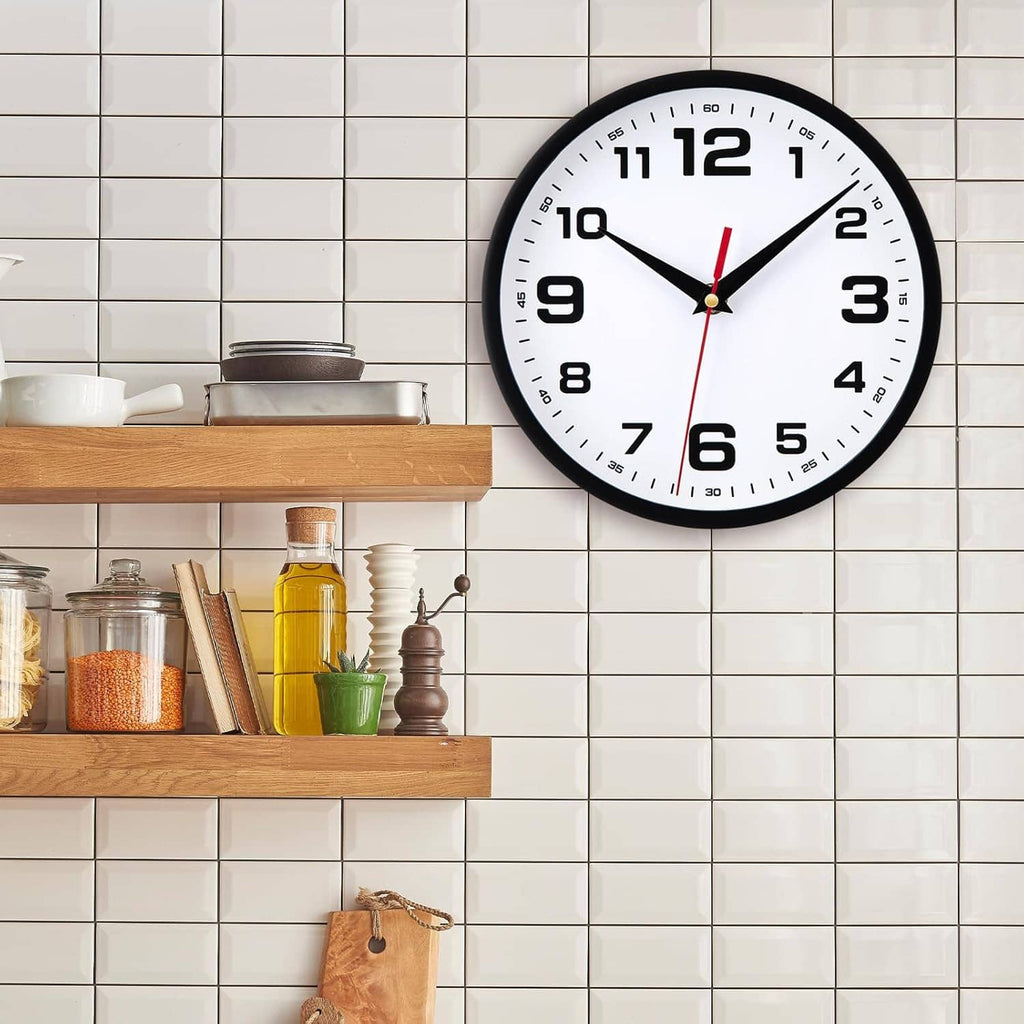 Black round analog wall clock with white face, large numerals, red second hand