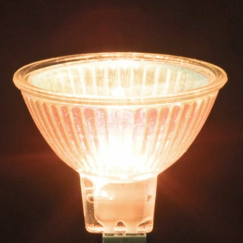 Glowing MR16 halogen spotlight bulb with warm light through clear reflector glass