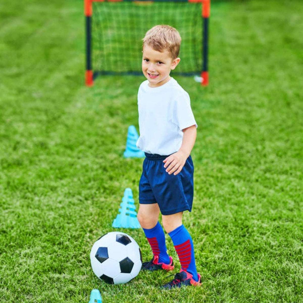 White and black soccer ball near a child’s feet