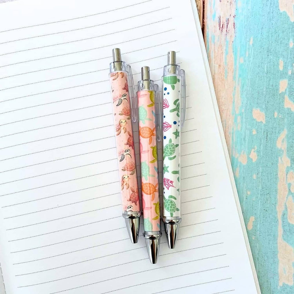 Two turtle-print pens with clear barrels and silver tips