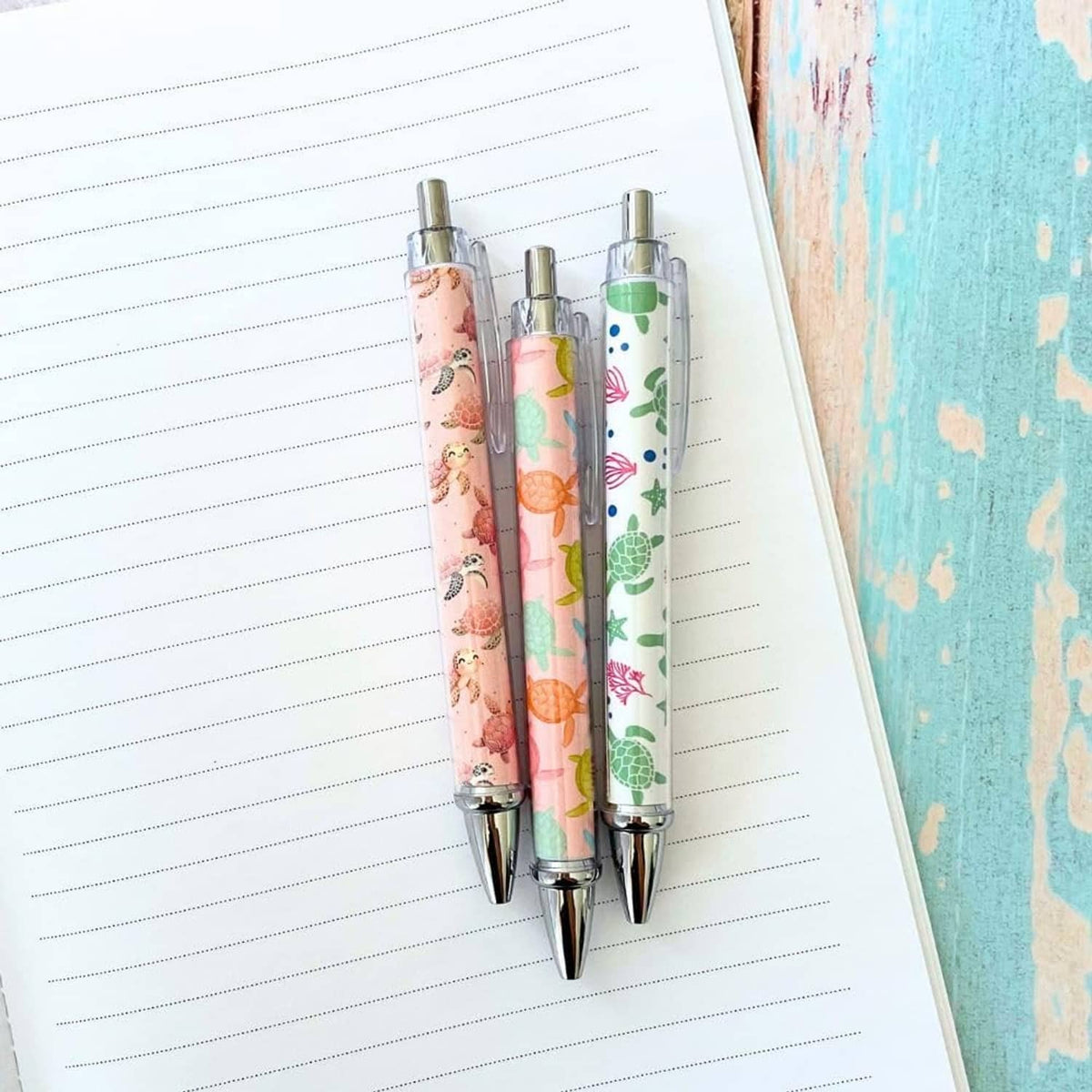 Two turtle-print pens with clear barrels and silver tips