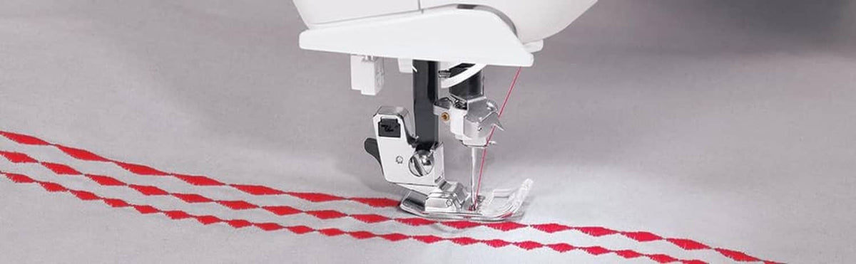 Sewing machine with heavy duty needle stitching red-and-white fabric