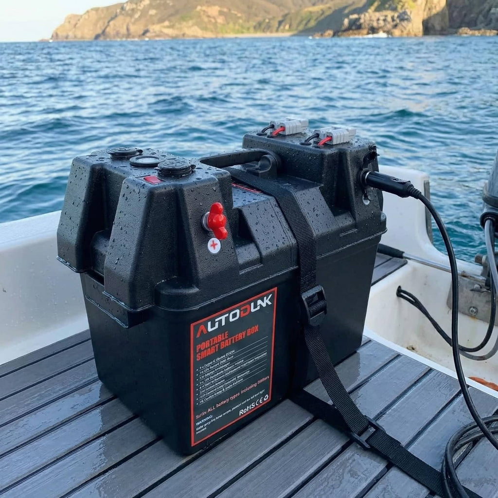 Portable 12V battery power box on boat deck with red plus terminal and cable outlet