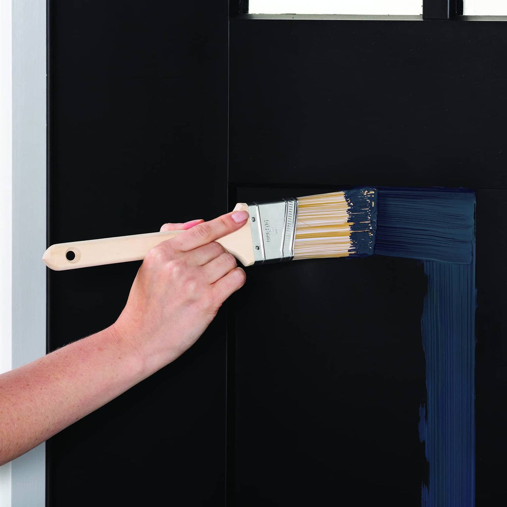 Dark navy door coated with satin paint using a brush