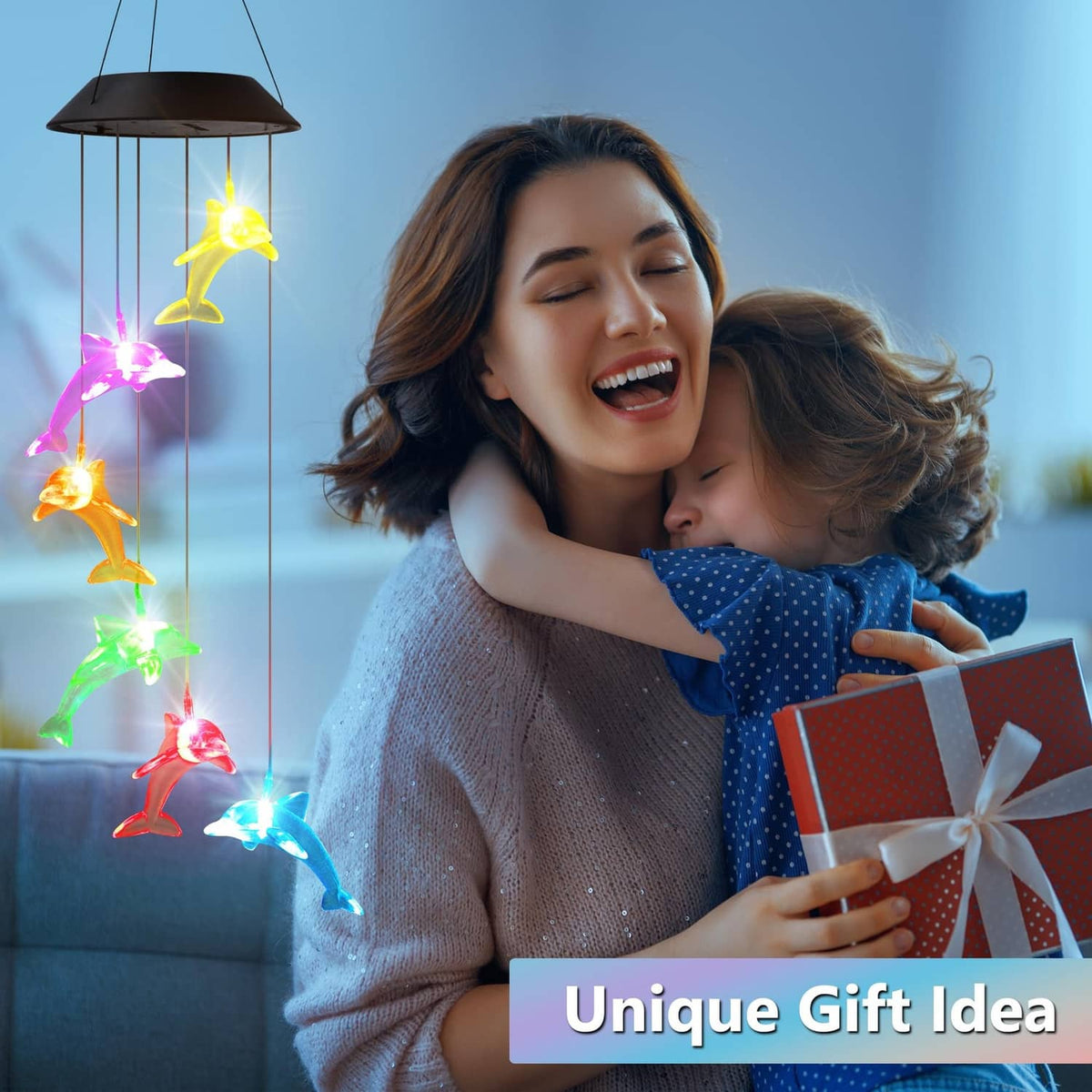 Mom holding a gift next to glowing multicolor solar dolphin wind spinner lights
