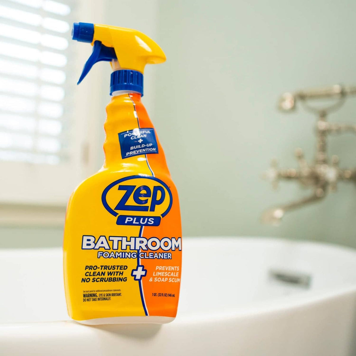 Zep Plus Bathroom foaming cleaner spray bottle on sink surface, blue trigger, yellow-orange