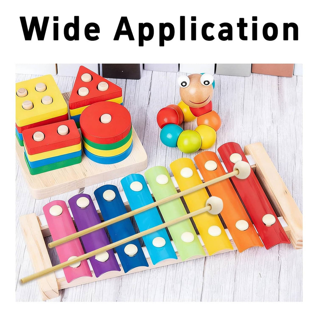 Wood percussion mallets with round white heads over colorful xylophone bars