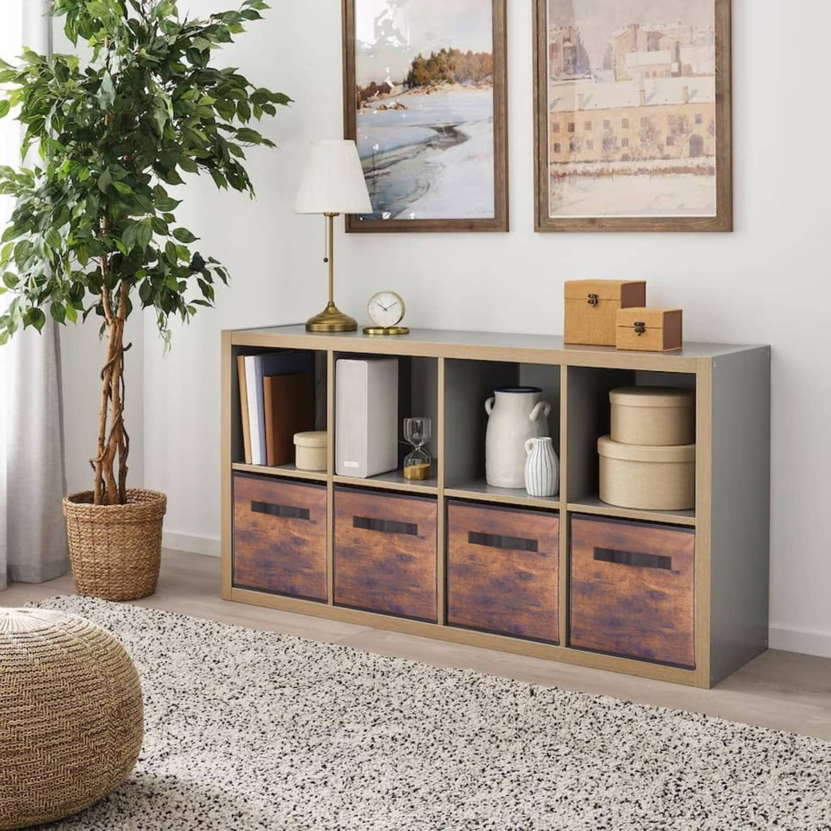 Fabric storage bins with wood-grain front panels and black pull handles in a console cabinet.