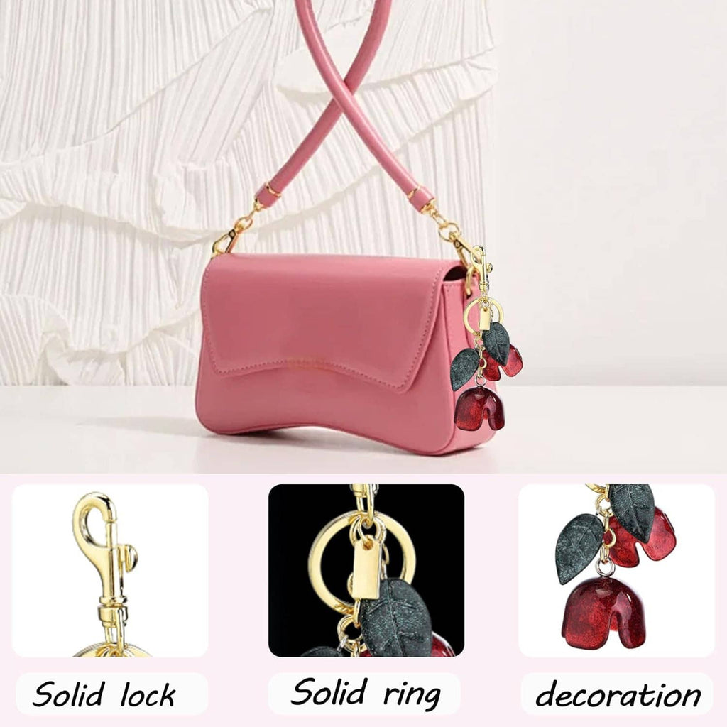 Flower bag charm keychain with gold clasp and dark green plus red petal dangles