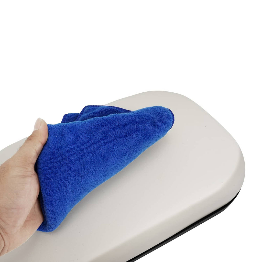 White seat cushion with black trim edge, hand holding a cleaning cloth