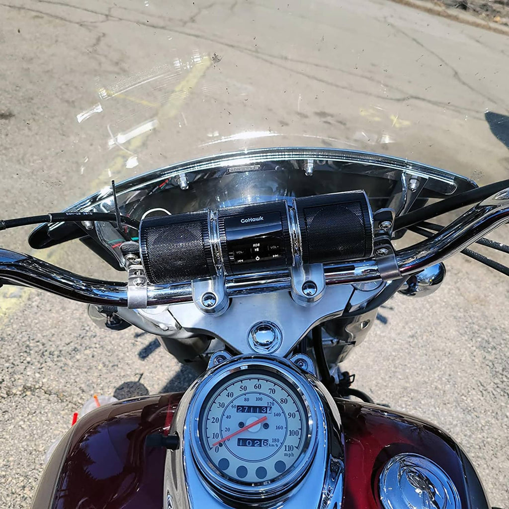 Black motorcycle stereo speakers installed near the bike gauges with chrome mounting rings