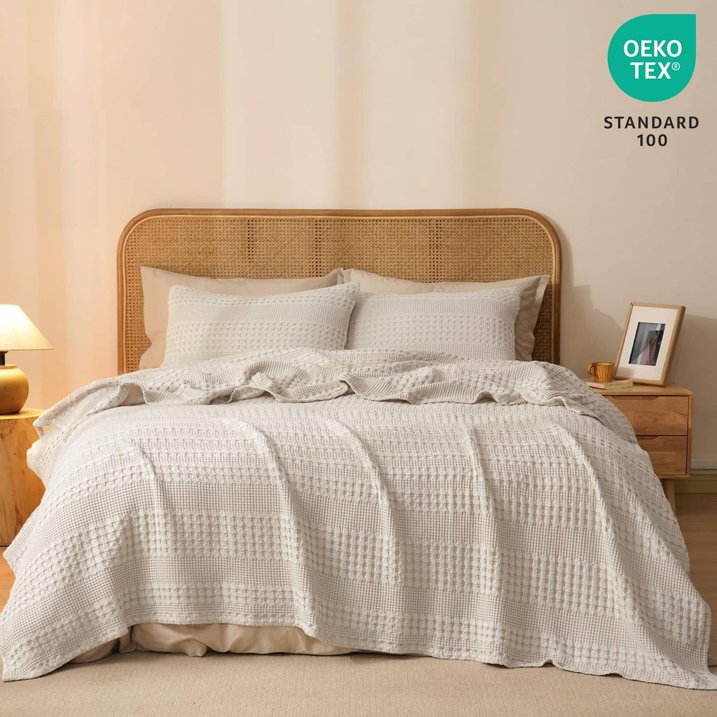 Ivory waffle-weave cotton blanket on a bed with matching pillowcases and textured weave