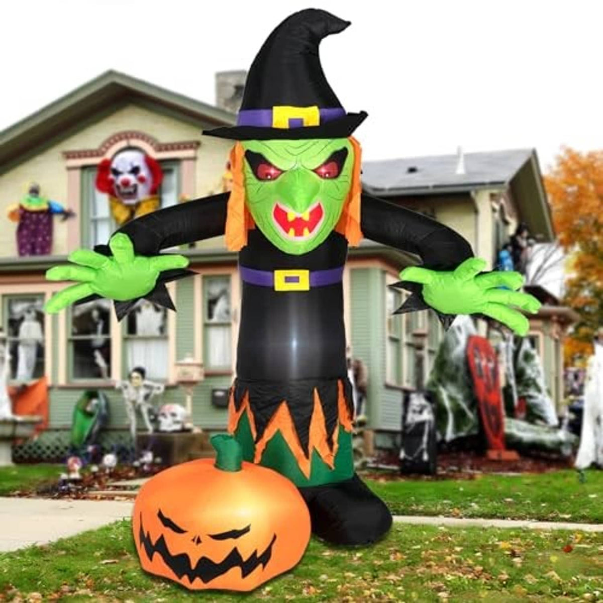 Inflatable Halloween witch decoration with green grinning face, black hat, and orange pumpkin