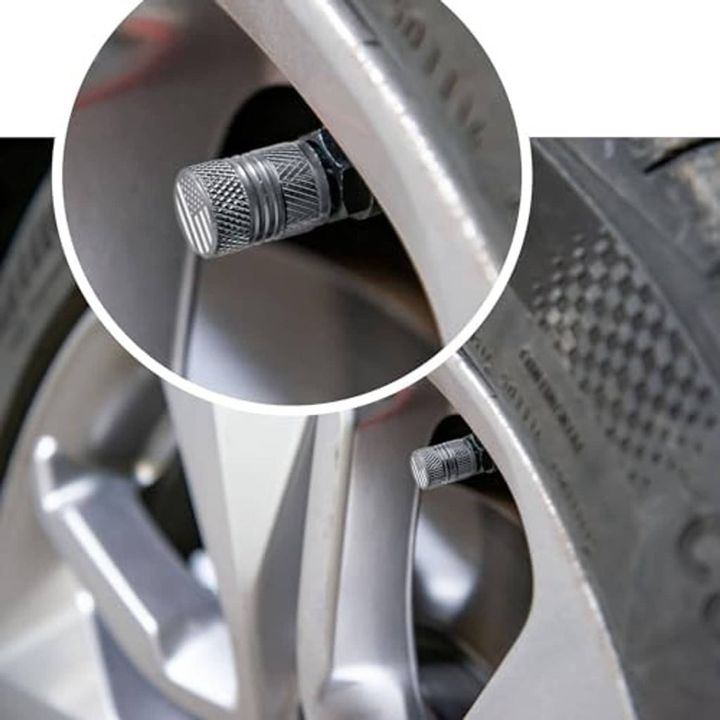 Grey textured valve stem cap installed on a wheel rim valve opening