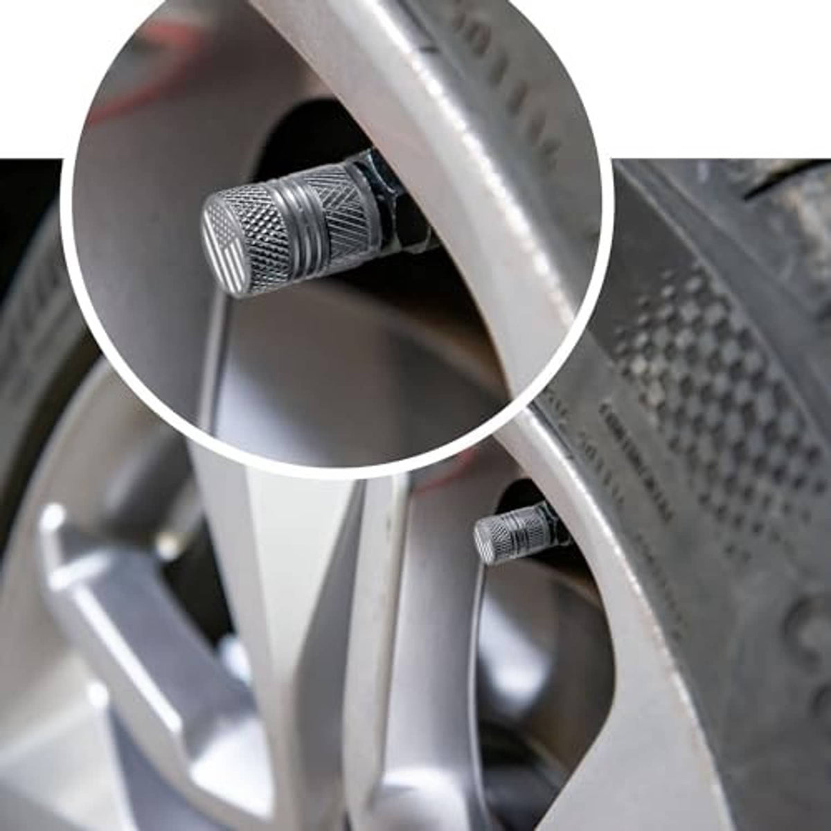 Grey textured valve stem cap installed on a wheel rim valve opening