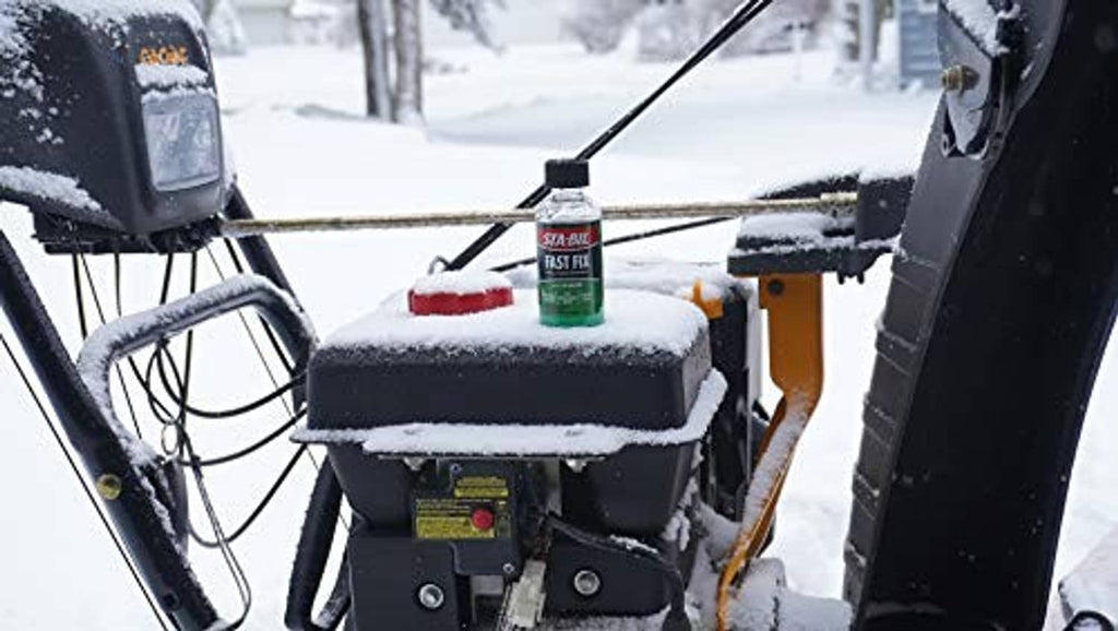 STA-BIL Fast Fix bottle sitting on snowy engine equipment