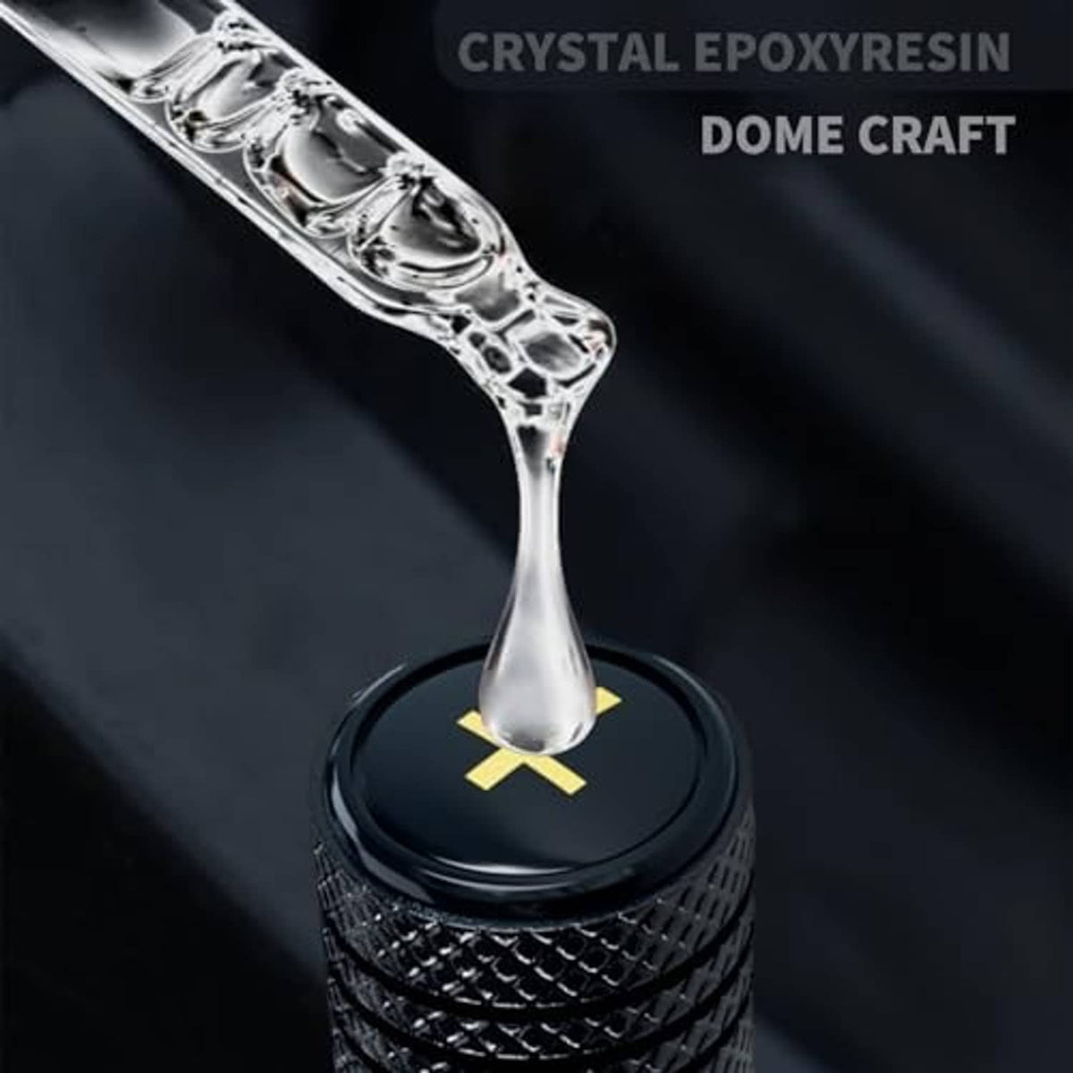 Black metal tire valve stem cap with yellow cross emblem, standalone
