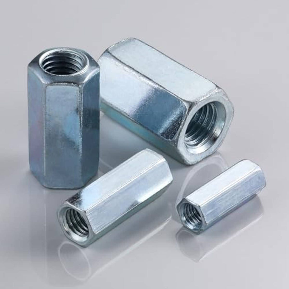 Zinc-plated extended hex rod coupling nuts with threaded internal holes, shown with extra pieces