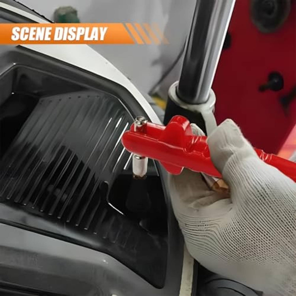 Red car tire valve stem puller tool with T-handle held near a wheel valve