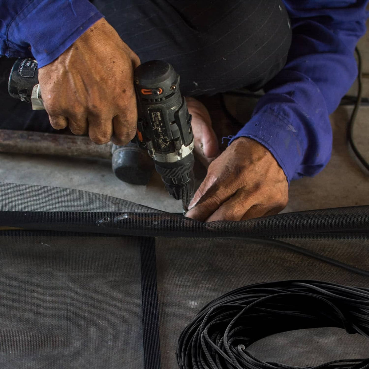 Black window screen spline installation, pressed into window track with tool