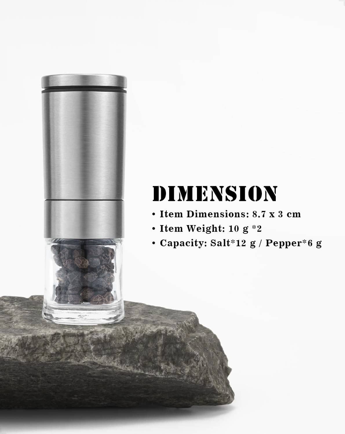 Stainless steel mini salt and pepper grinder with clear chamber on dark stone base