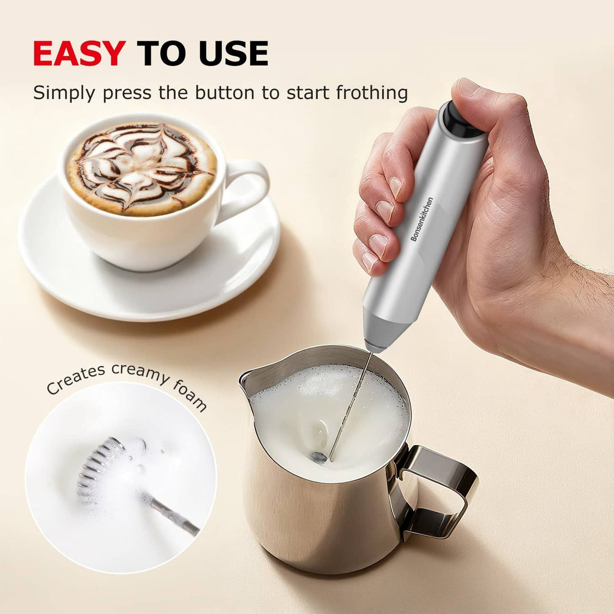Handheld silver milk frother over saucepan, producing frothy milk foam