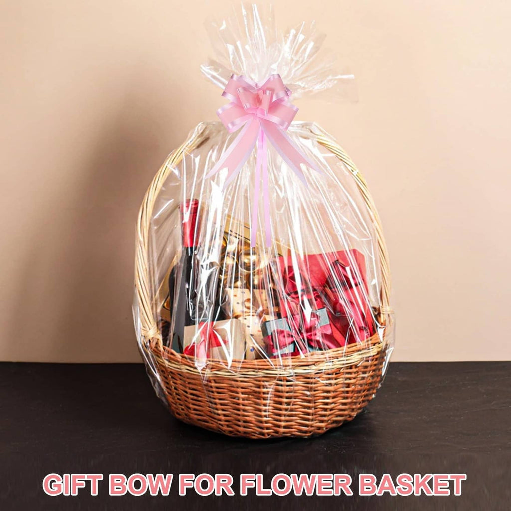 Pink gift bow topper on a wrapped basket, with long ribbon tails