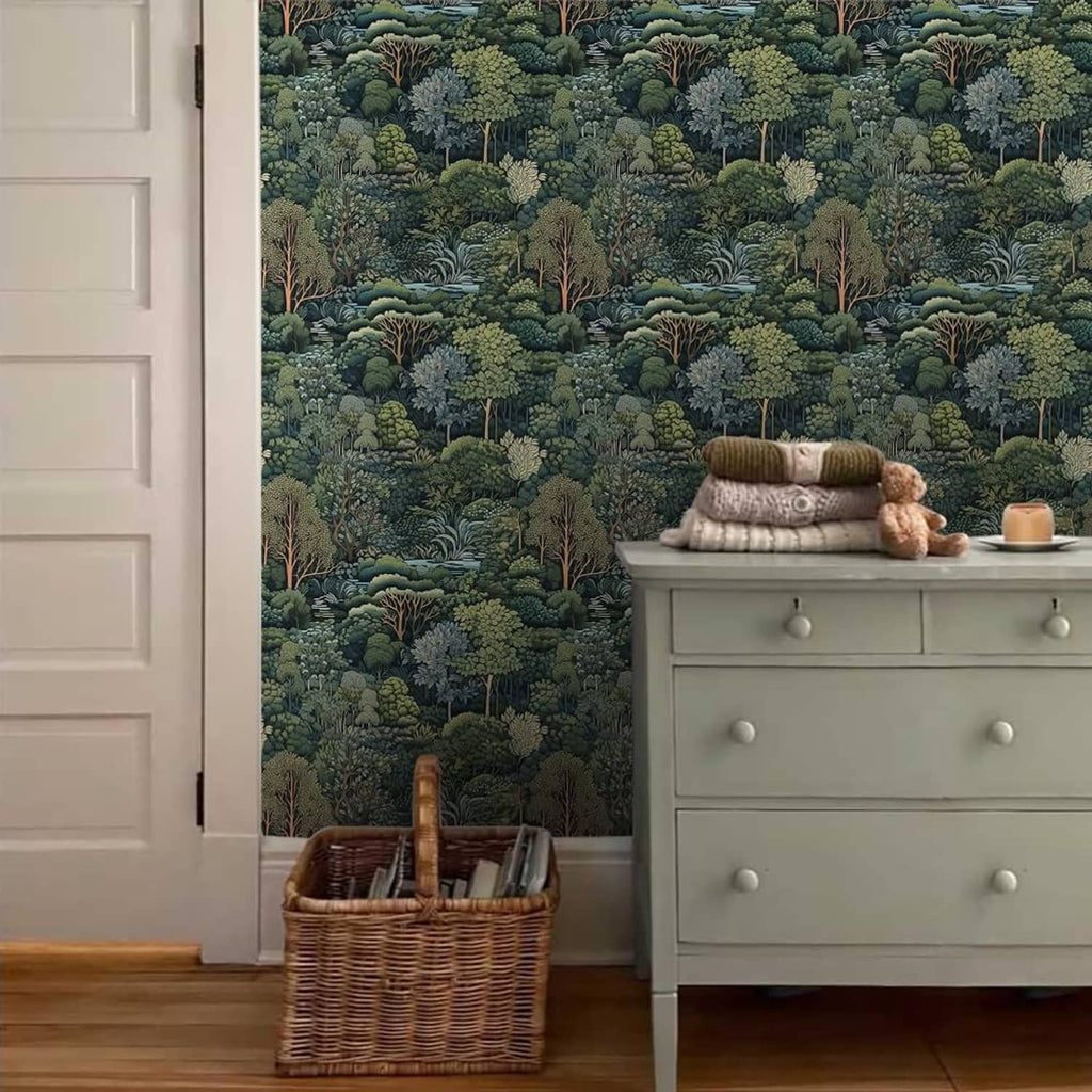Green forest tree mural wallpaper covering a wall behind a dresser and storage basket