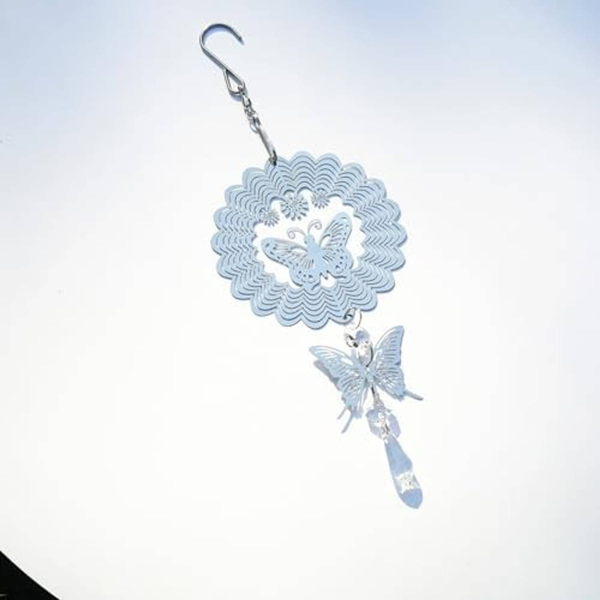Light blue-tinted silver wind spinner with sunburst medallion, butterflies, and crystal charm.