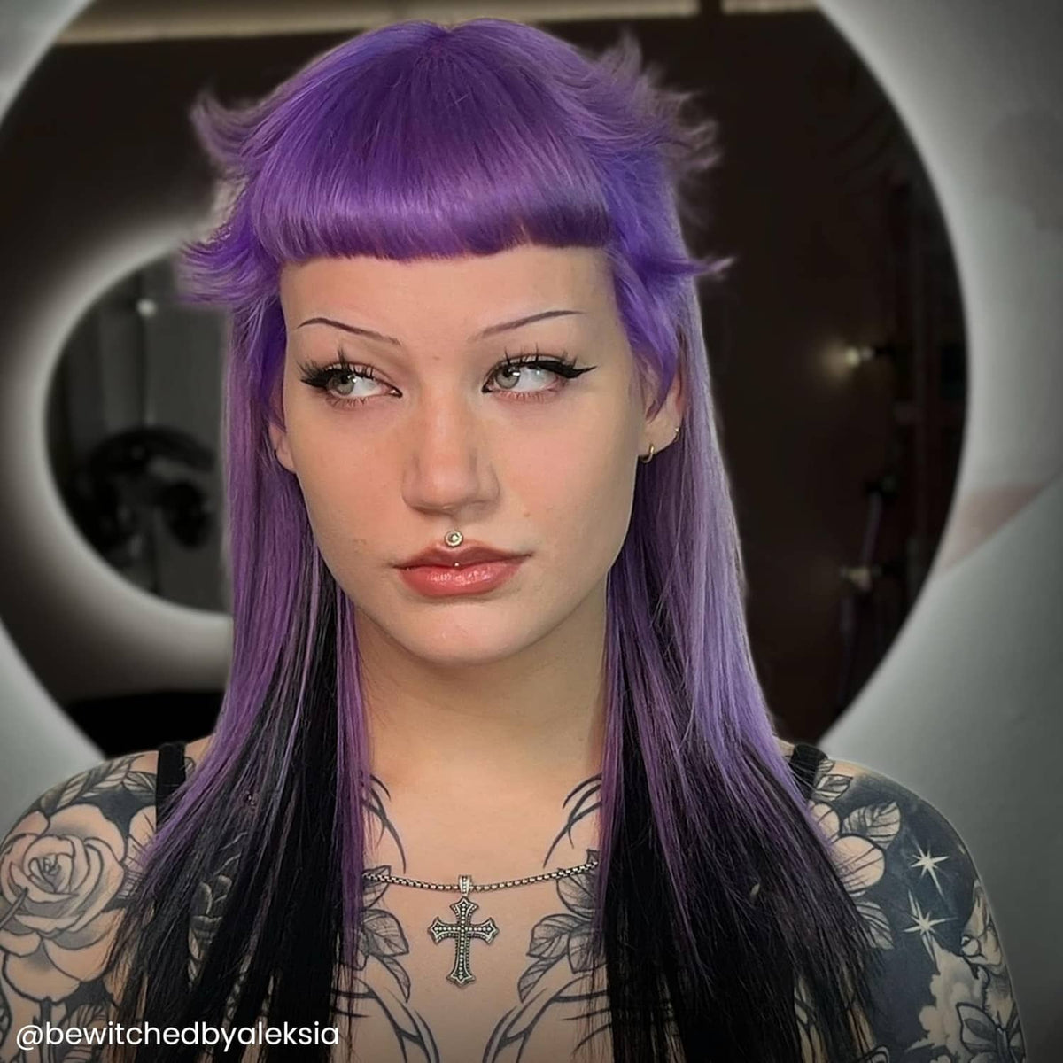 Short-to-medium purple hair with bangs and high style; semi-permanent color result