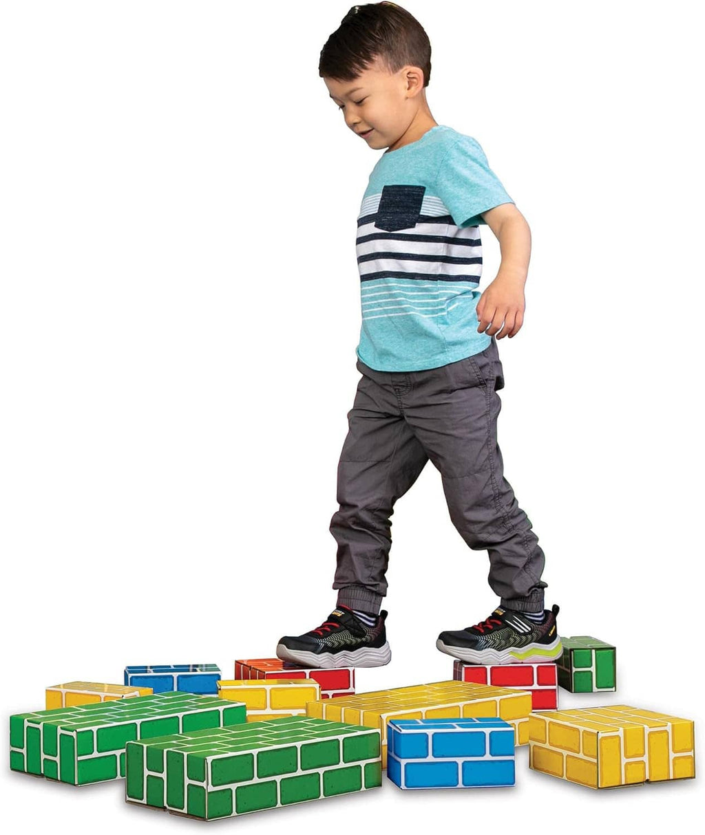 Child standing among colorful cardboard brick blocks arranged in stacks