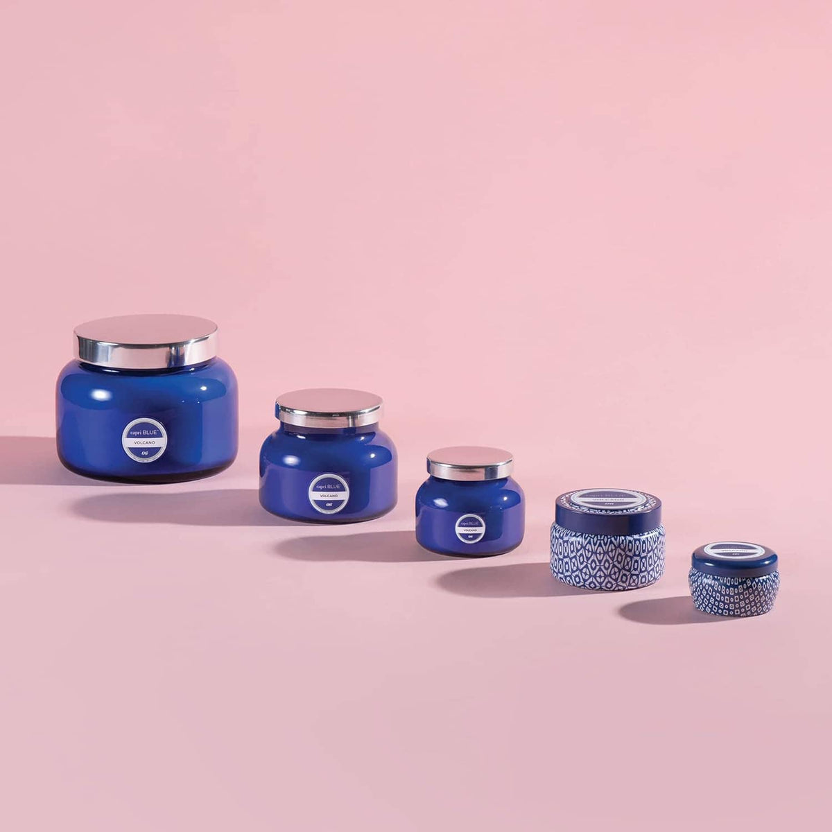 Set of blue glass jar candles in multiple sizes with matching metal lids