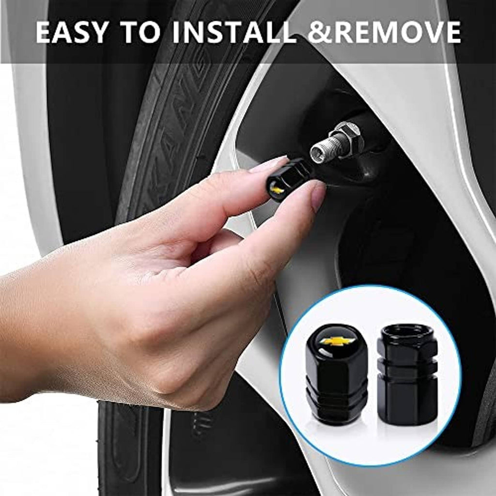 Hand installing a black tire valve stem cap with gold bowtie logo