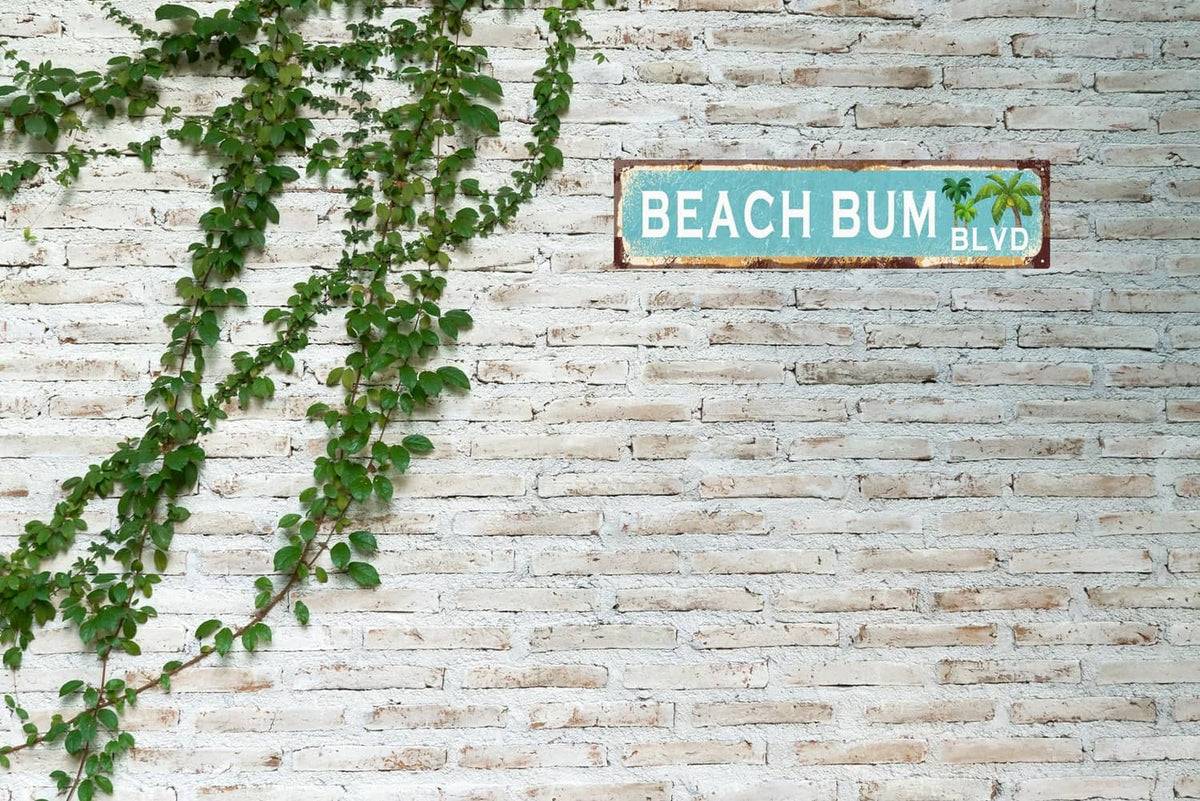 Rectangular vintage tin sign reading “BEACH BUM” with “BLVD” and palm tree