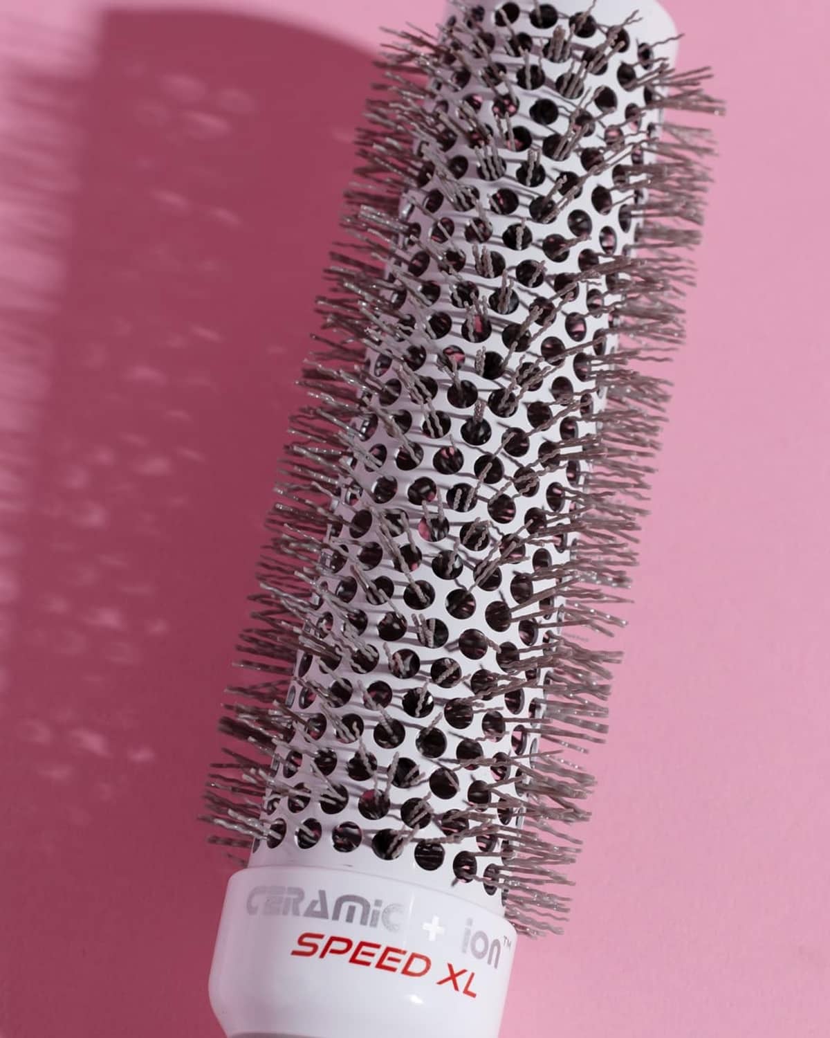 Close-up of extra-long round hair brush with ceramic+ion bristle barrel and grey base.