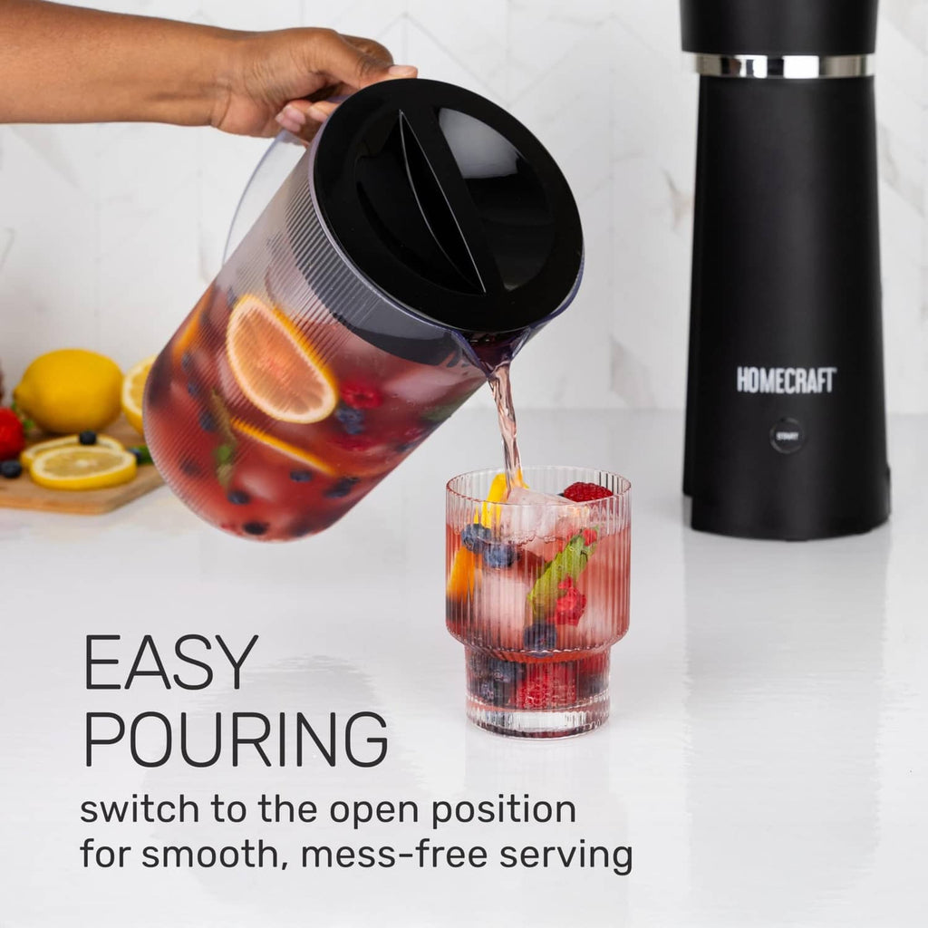 Black iced tea maker with hand pouring from the clear pitcher into a drinking glass