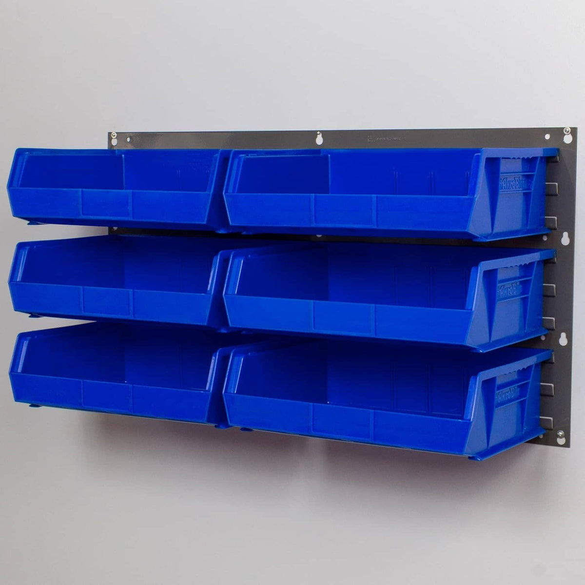Gray louvered panel with four blue storage bins for wall mounting