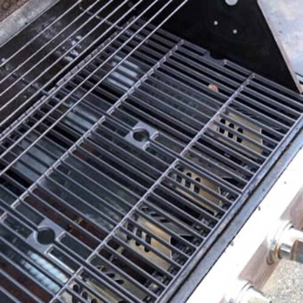 Stainless steel grill heat plate grids installed inside the grill with bars visible