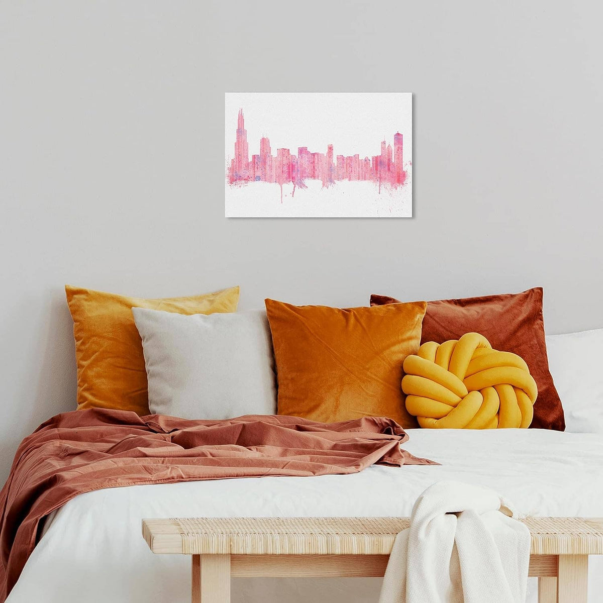 Wrapped canvas wall art featuring a pink city skyline above an orange bedding set