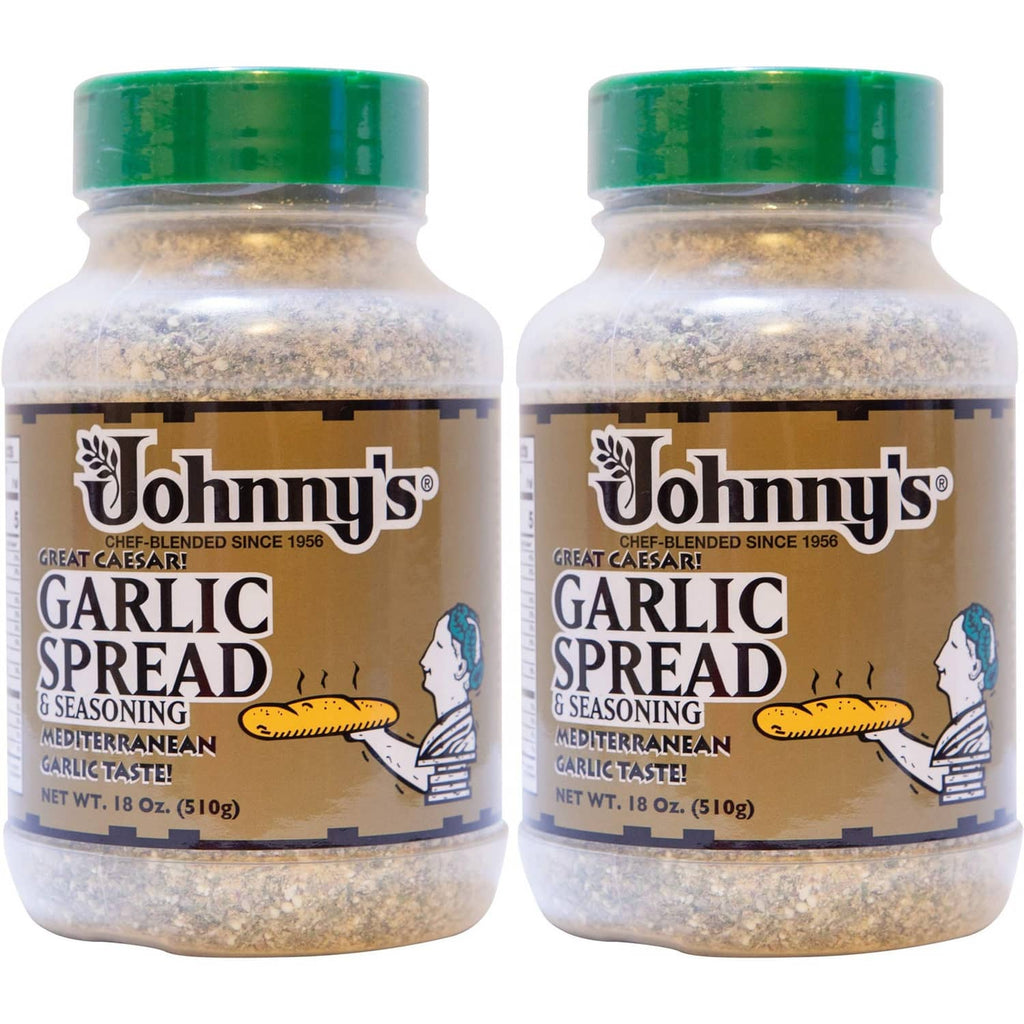 Pair of garlic spread seasoning bottles with green caps and tan speckled contents