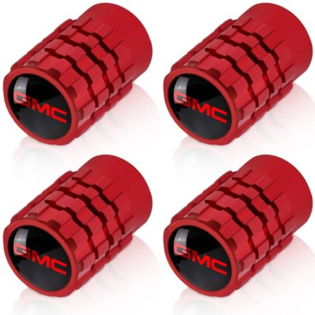 Four red tire valve stem caps with GMC logo, ridged texture on the cylindrical ends