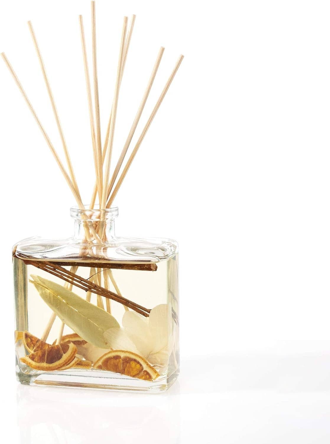 Close view of clear reed diffuser bottle with tan reeds and citrus peel pieces inside