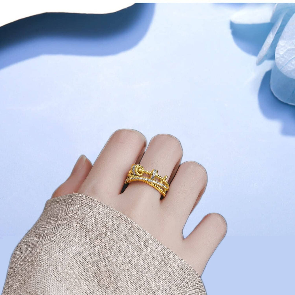Gold-tone fidget ring with clear stone bands on an open hand